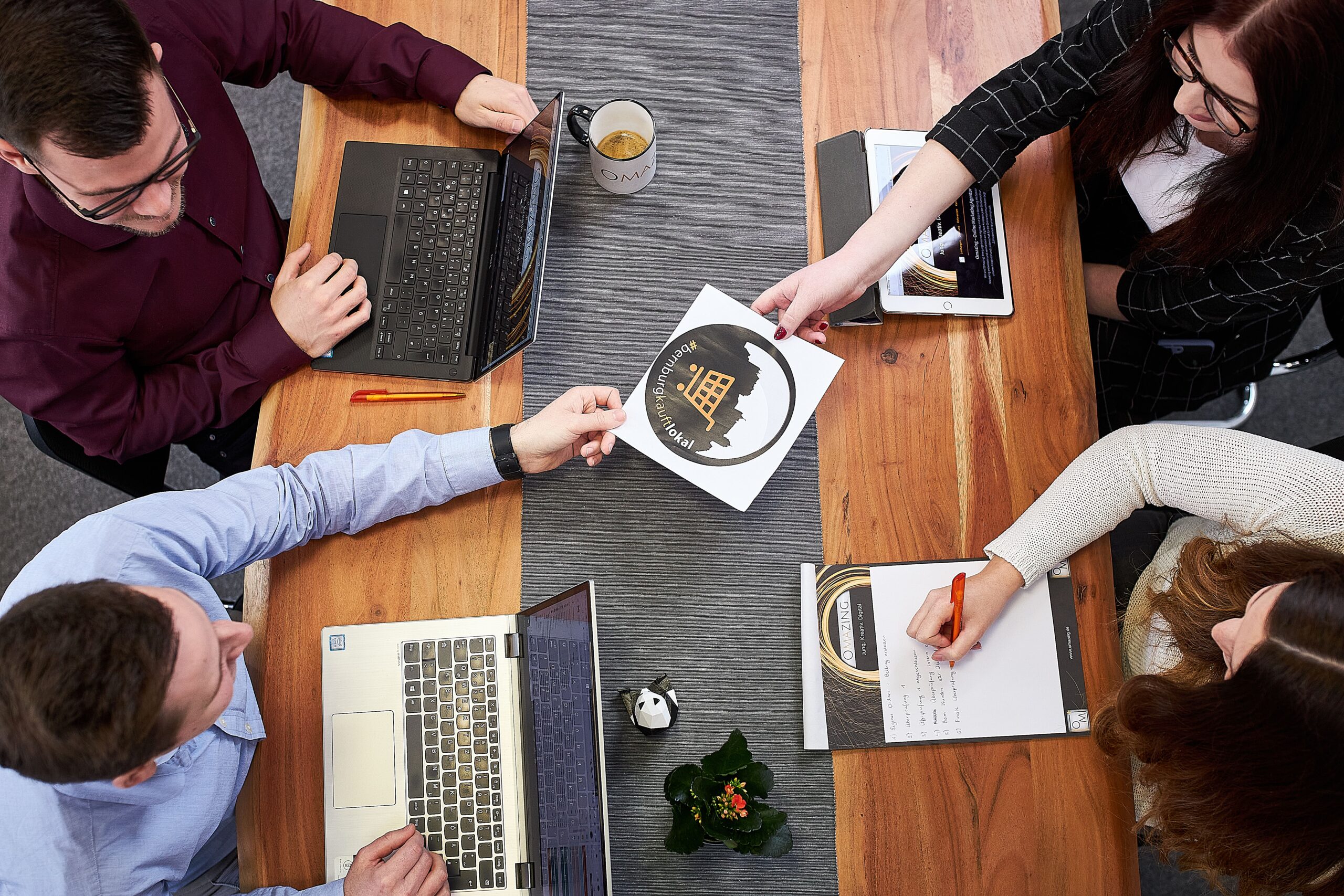 Am Tisch sitzen vier Personen, die über ein Projekt im Online-Marketing-Bereich reden.